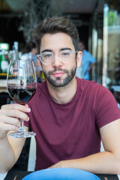 Foto giovane uomo caucasico che beve un vino