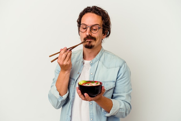 Young caucasian man eating a ramen isolated on white