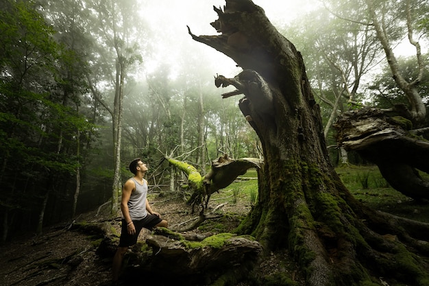 Young caucasian man exploring a foggy forest in Artikutza, Basque Country