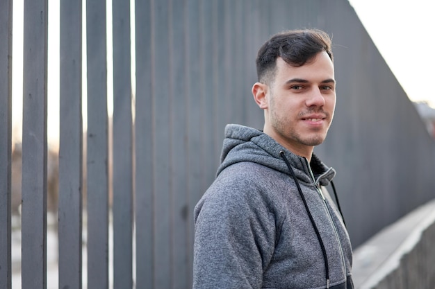 Young caucasian man exudes coolness leaning in the street