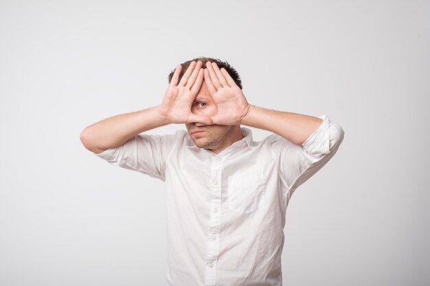 Photo young caucasian man hiding his face with hand