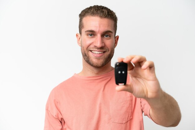 Young caucasian man holding car keys isolated on white background with happy expression