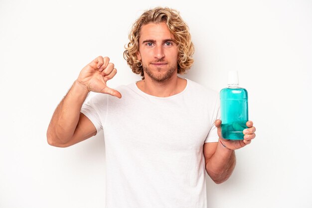 Young caucasian man holding a clapperboard isolated on white background showing a dislike gesture, thumbs down. Disagreement concept.