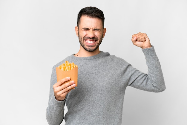 強いジェスチャーをしている分離の白い背景の上にフライド チップスを保持している若い白人男性