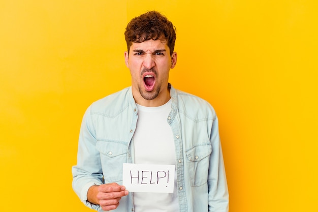 Young caucasian man holding a help placard isolated