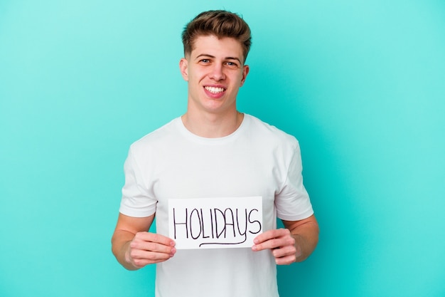Young caucasian man holding a Holidays placard isolated
