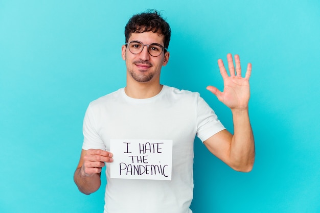 Young caucasian man holding a I hate the pandemic placard isolated