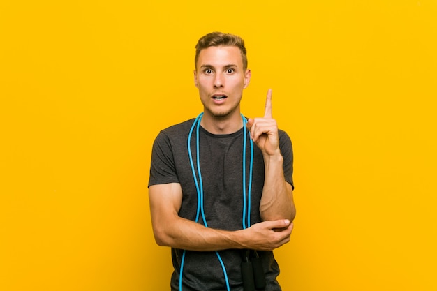 Young caucasian man holding a jump rope having some great idea, concept of creativity.