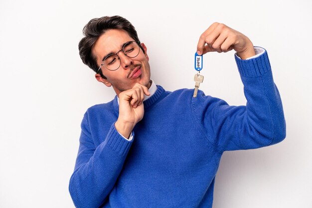 Young caucasian man holding a key chain isolated on white background