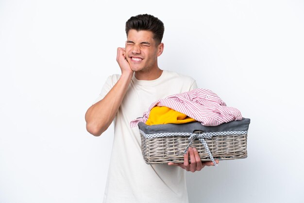 Young caucasian man holding laundry basket isolated on white background frustrated and covering ears