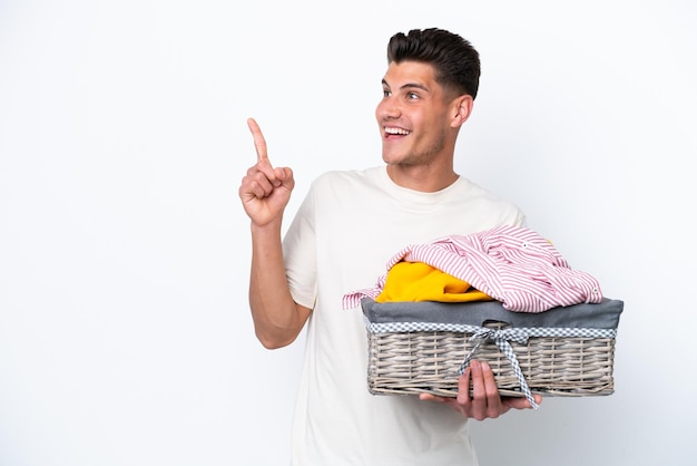 Young caucasian man holding laundry basket isolated on white background intending to realizes the solution while lifting a finger up