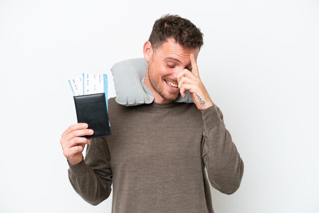 Young caucasian man holding a passport isolated on white background laughing