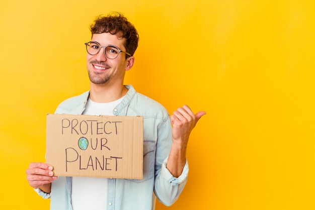 Young caucasian man holding a protect our planet placard