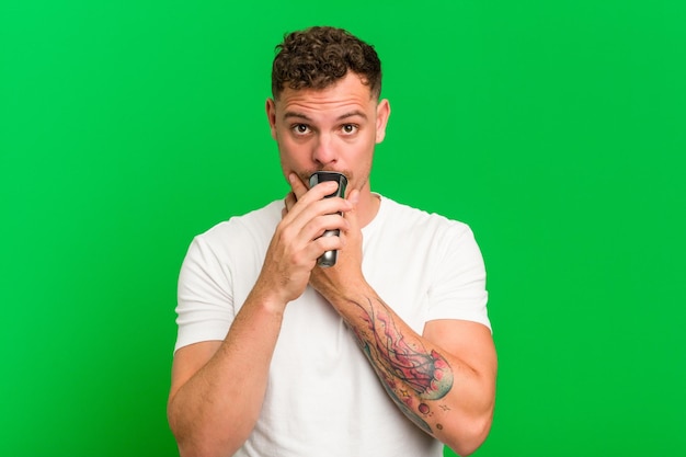 Young caucasian man holding a razor isolated