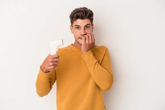 Young caucasian man holding thermometer isolated on white background biting fingernails, nervous and very anxious.