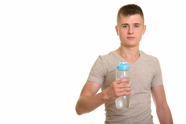 Young Caucasian man holding water bottle and looking at camera