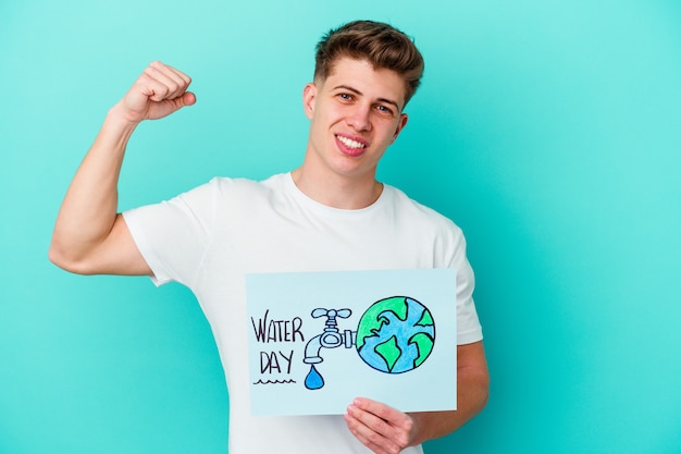 Young caucasian man holding a water day placard isolated on blue