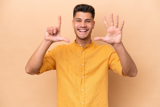 Young caucasian man isolated on beige background counting seven with fingers