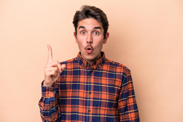 Young caucasian man isolated on beige background having some great idea, concept of creativity.