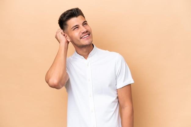 Young caucasian man isolated on beige background thinking an idea