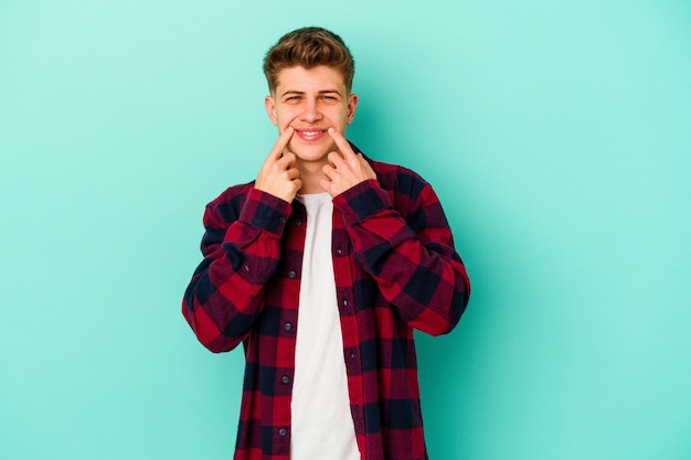 Young caucasian man isolated on blue background doubting between two options.