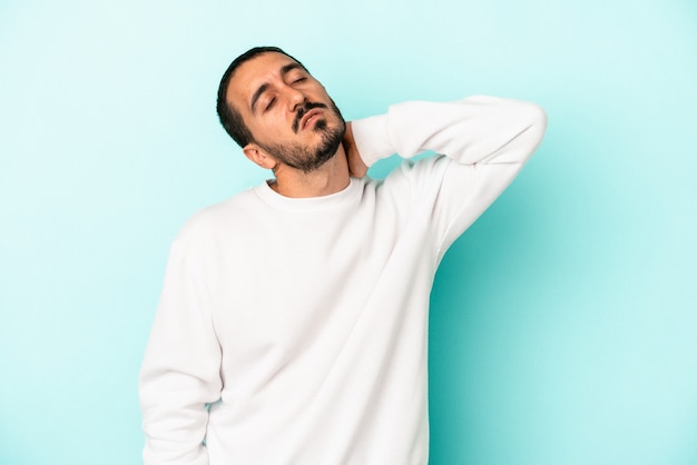 Young caucasian man isolated on blue background massaging elbow, suffering after a bad movement.