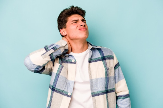 Young caucasian man isolated on blue background massaging elbow suffering after a bad movement