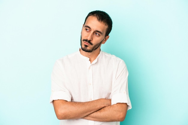 Young caucasian man isolated on blue background smiling confident with crossed arms.