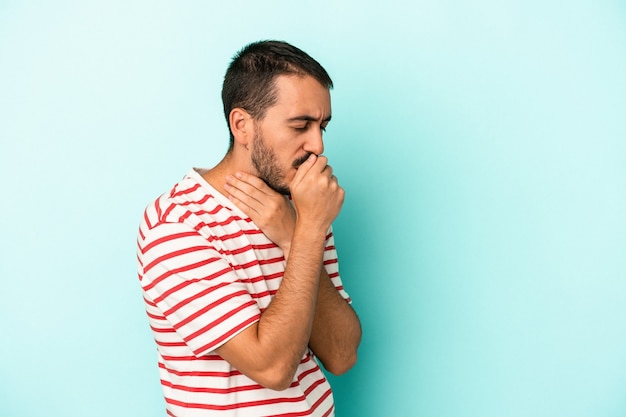 Young caucasian man isolated on blue background suffers pain in throat due a virus or infection.