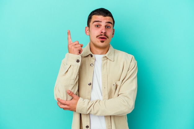 Young caucasian man isolated on blue having some great idea, concept of creativity.