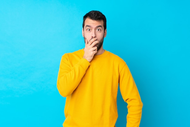 Young caucasian man over isolated blue surprised and shocked while looking right