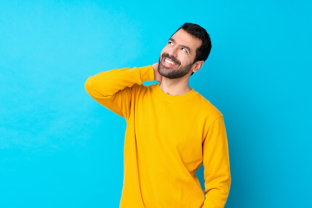 Young caucasian man over isolated blue wall thinking an idea