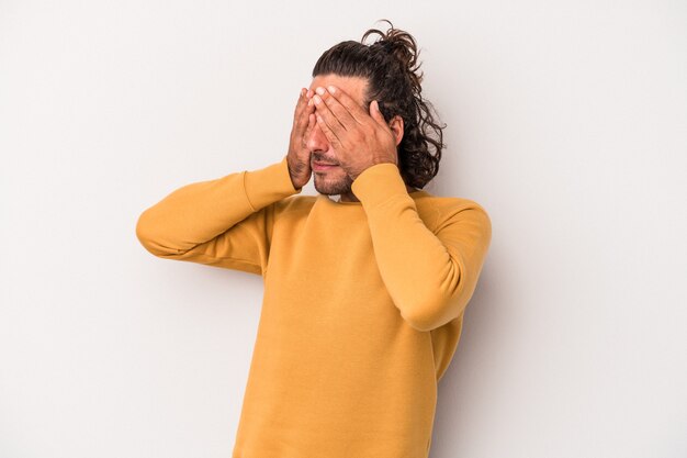 Photo young caucasian man isolated on gray background afraid covering eyes with hands.