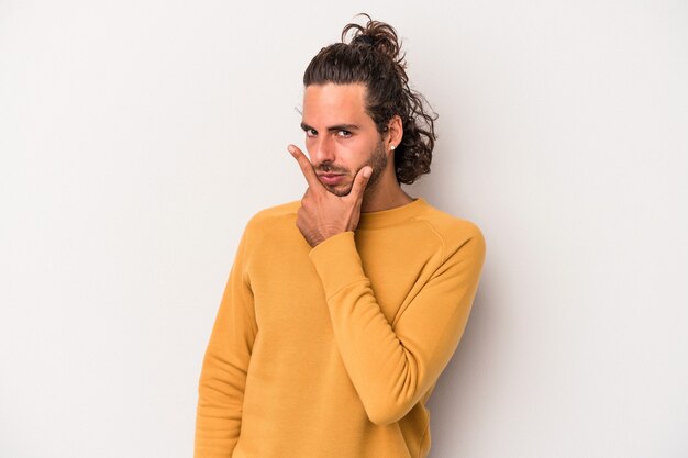 Young caucasian man isolated on gray background contemplating, planning a strategy, thinking about the way of a business.