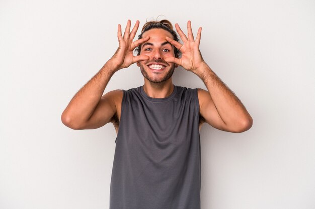 Young caucasian man isolated on gray background keeping eyes opened to find a success opportunity.