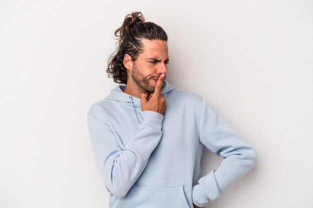 Young caucasian man isolated on gray background keeping a secret or asking for silence.