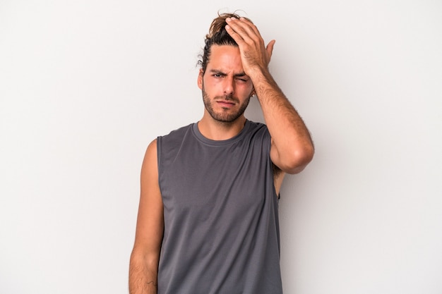 Young caucasian man isolated on gray background tired and very sleepy keeping hand on head.