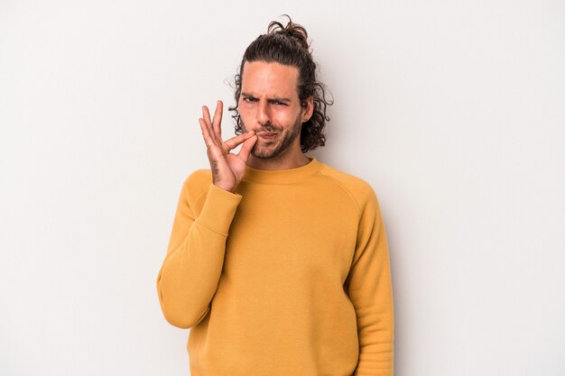 Young caucasian man isolated on gray background with fingers on lips keeping a secret.