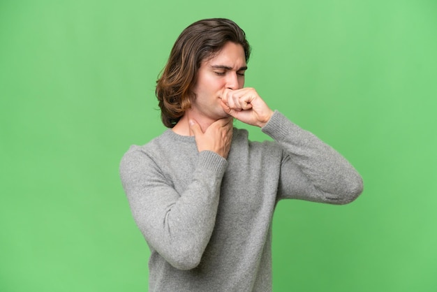 Foto giovane uomo caucasico isolato su sfondo verde croma che tossisce molto