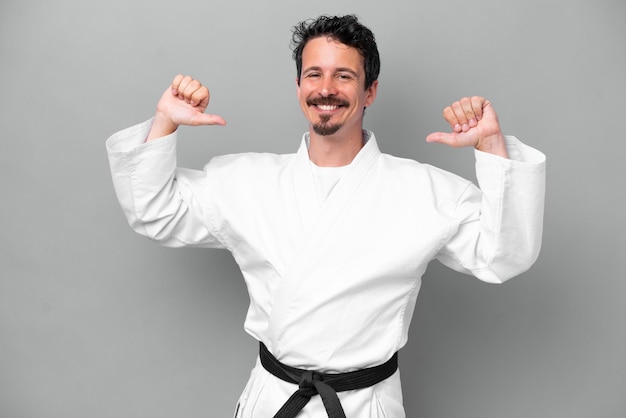 Photo young caucasian man isolated on grey background proud and selfsatisfied