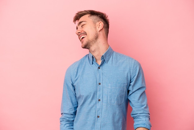 Young caucasian man isolated on pink background dancing and having fun.