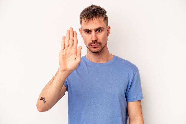 Young caucasian man isolated on pink background joyful and carefree showing a peace symbol with fingers.