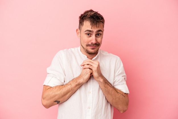 Young caucasian man isolated on pink background scared and afraid.