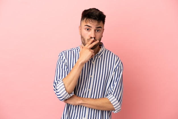 Young caucasian man isolated on pink background surprised and shocked while looking right