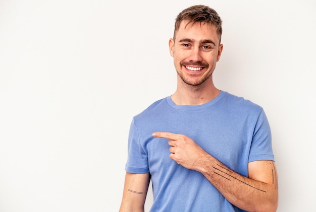 Young caucasian man isolated on pink background trying to listening a gossip.