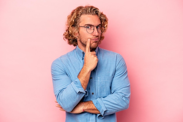 Photo young caucasian man isolated on pink background unhappy looking in camera with sarcastic expression.