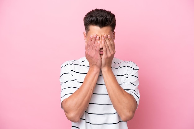 Young caucasian man isolated on pink background with tired and sick expression