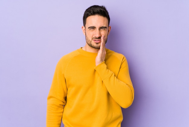 Young caucasian man isolated on purple having a strong teeth pain, molar ache.