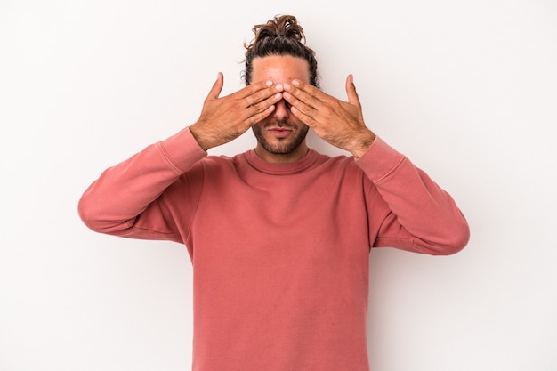 Young caucasian man isolated on white background afraid covering eyes with hands.