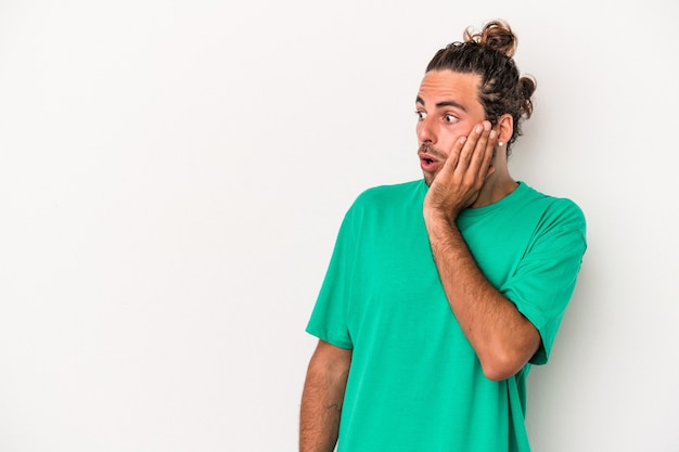 Young caucasian man isolated on white background being shocked because of something she has seen.